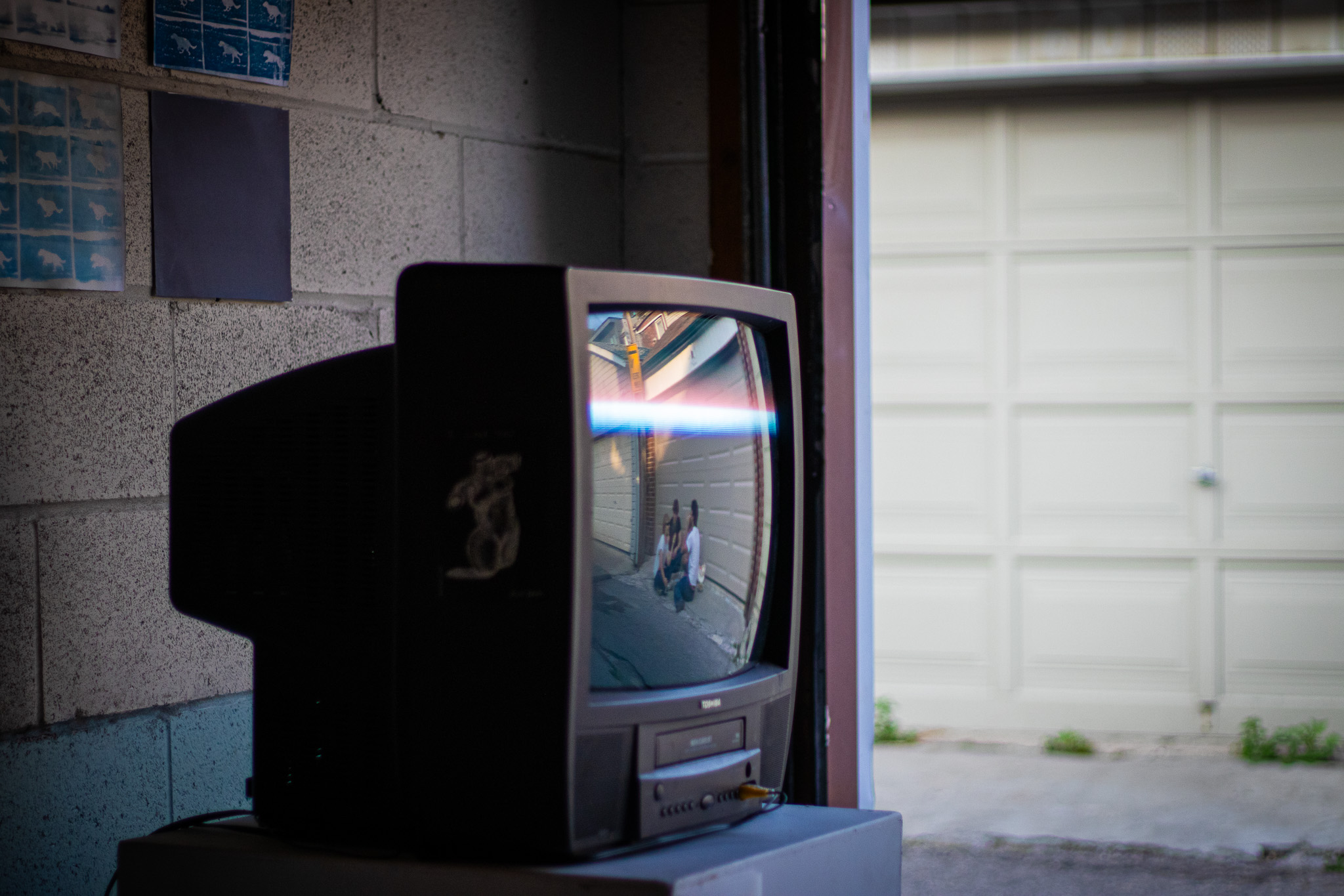 A CRT television beside an open garage doorway